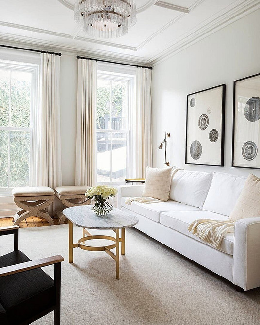 Білий шкіряний диван в сучасному інтер'єрі з чорними акцентами.