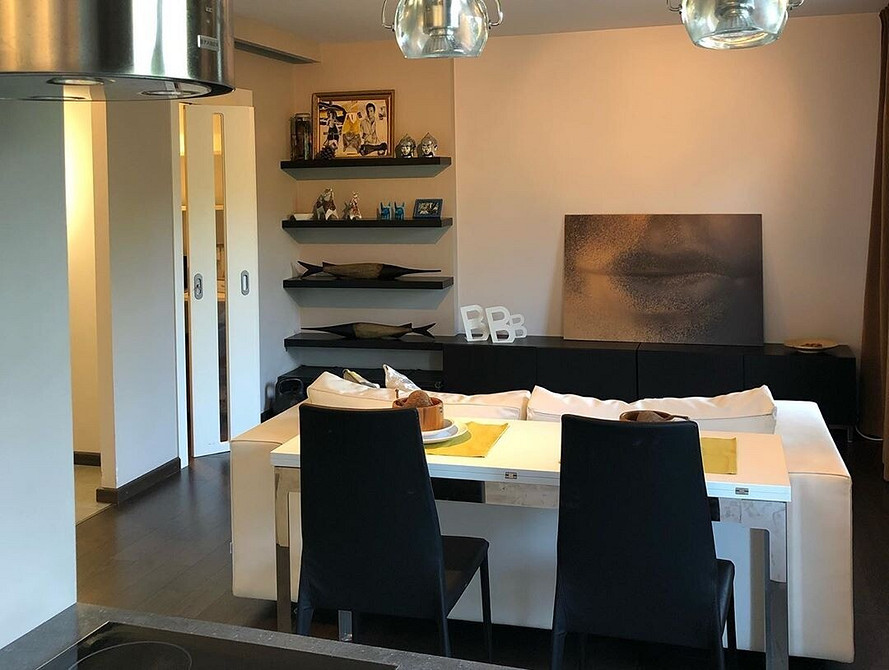 Затишний куточок з білим диваном, пледом та декоративними свічками.