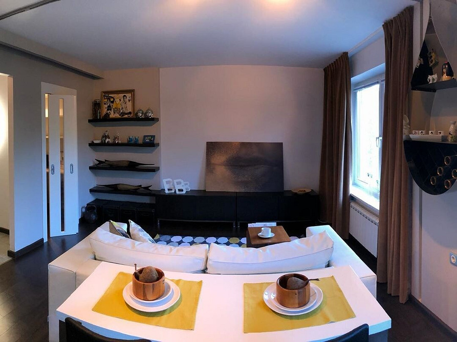 Інтер'єр з білим кутовим диваном та журнальним столиком в мінімалістичному стилі.