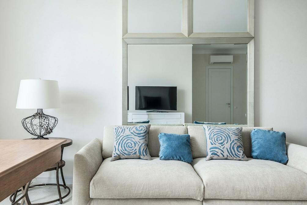 Білий диван в еклектичному інтер'єрі з поєднанням різних стилів та текстур.