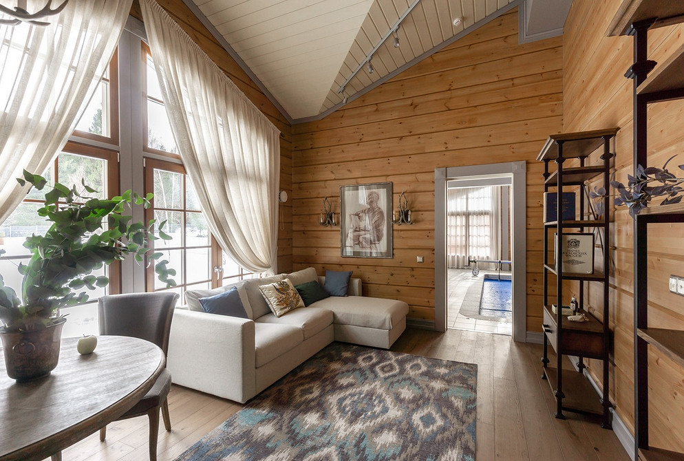 Інтер'єр з білим диваном, картинами на стінах та яскравими акцентами в стилі бохо.