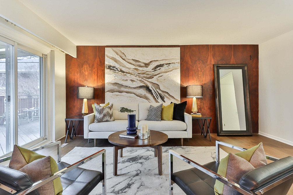 Сучасний дизайн вітальні з білим диваном, сірою стіною та декоративним освітленням.