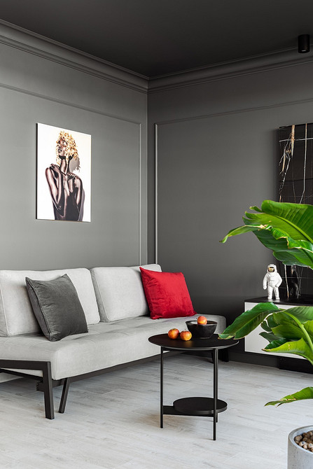 Інтер'єр вітальні з білим диваном, килимом та декоративними подушками різних кольорів