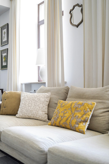 Інтер'єр вітальні з великим білим диваном: рослини та декор для затишку