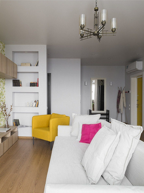 Сучасний інтер'єр з білим диваном, журнальним столиком та яскравими акцентами.