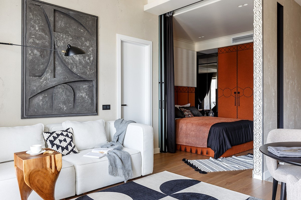 Затишна вітальня з білим диваном, каміном та теплим освітленням для відпочинку.