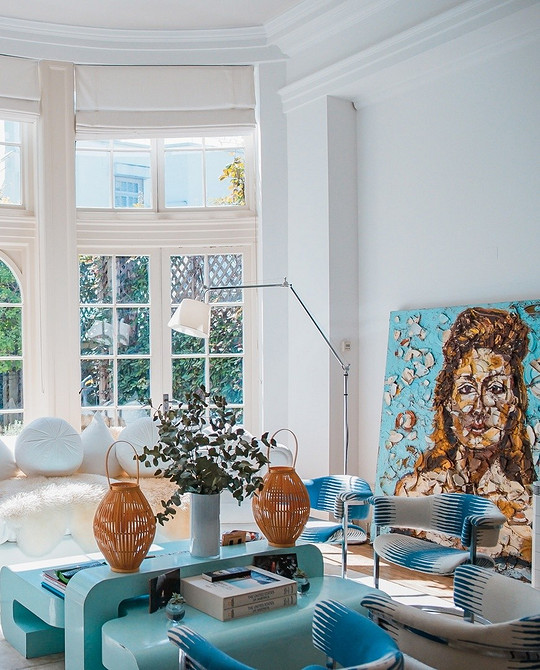 Білий диван з велюровою оббивкою в елегантному інтер'єрі з золотими деталями.