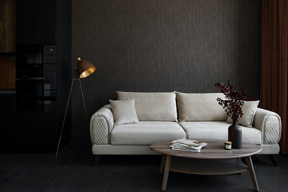 Білий диван з текстильною оббивкою в інтер'єрі скандинавського стилю з дерев'яними меблями.