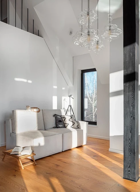 Білий диван в еко-стилі з лляними подушками та дерев'яним журнальним столиком.