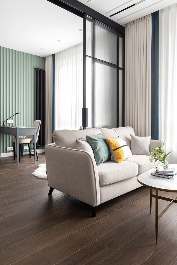 Білий шкіряний диван в інтер'єрі з каміном та дерев'яними елементами декору.