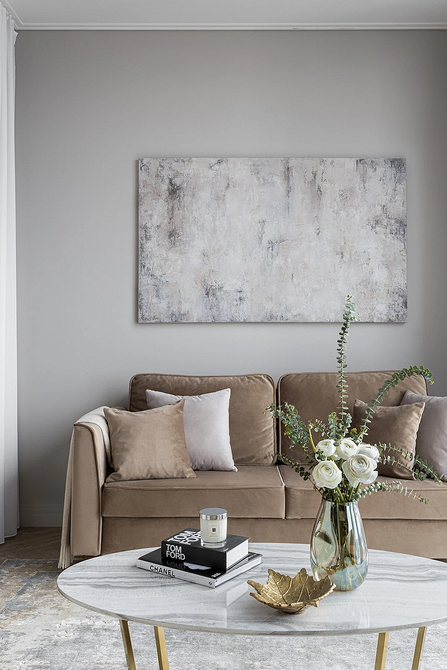 Розкладний бежевий диван в невеликій квартирі, функціональний дизайн інтер'єру, економія простору.