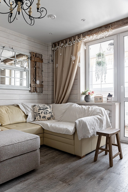 Стильний бежевий диван у вітальні з килимом та декоративними подушками для затишку