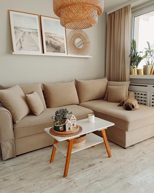 Сучасна вітальня з бежевим диваном, килимом та акцентними елементами декору.