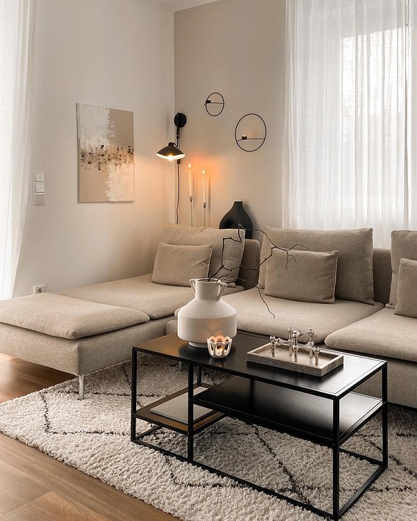 Бежевий диван в інтер'єрі вітальні, поєднаний з дерев'яними елементами та зеленими рослинами.