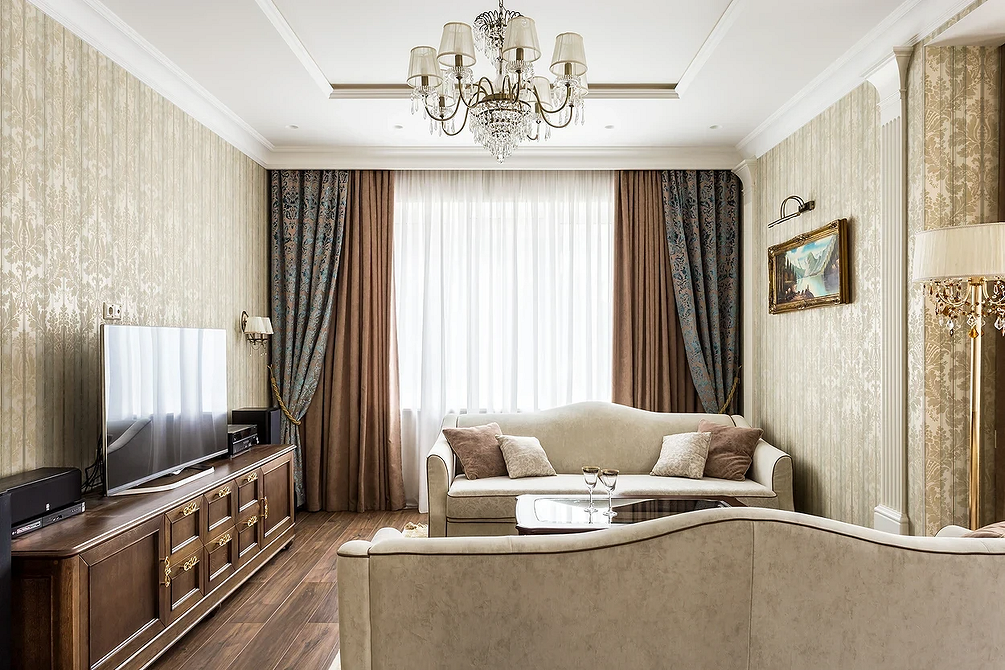 Елегантний бежевий диван у класичному інтер'єрі з дерев'яними елементами та текстилем.