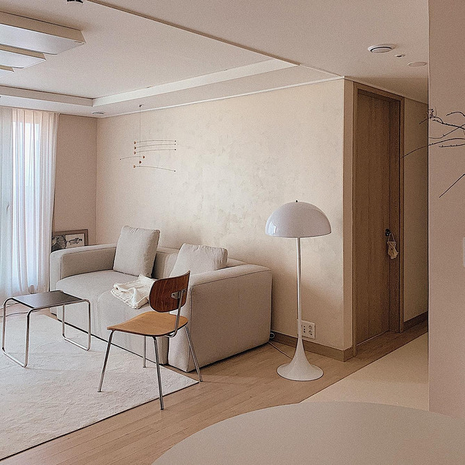 Елегантний бежевий диван з велюровою оббивкою в класичному інтер'єрі вітальні.