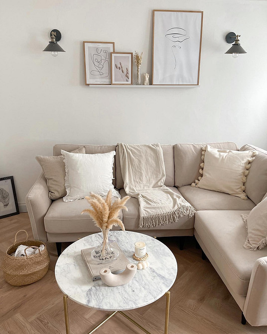 Стильний бежевий диван в сучасній вітальні з акцентними подушками та килимом.