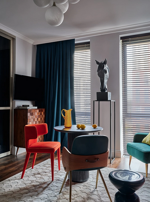 Кімната в стилі еклектика: дерев'яний стіл, пластикові стільці, килим з етнічним орнаментом.