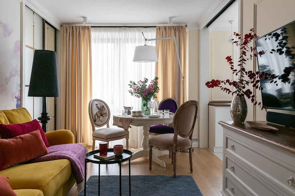 Еклектика в дизайні: сучасне крісло та вінтажна шафа в одному просторі.