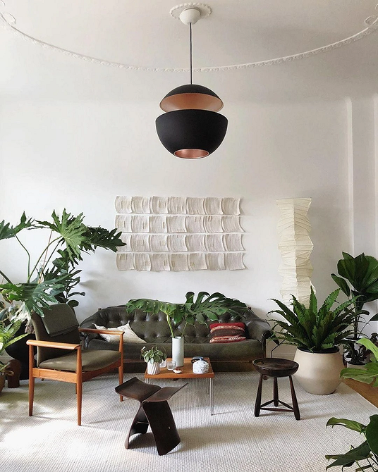 Еклектична спальня: ліжко з кованим узголів'ям, ретро тумбочка та сучасна лампа.