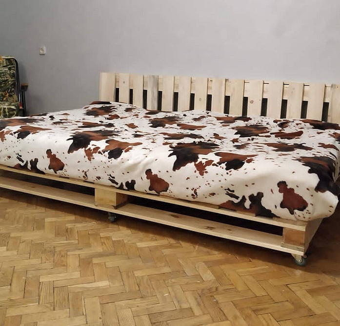 Елегантний диван з піддонів з оббивкою, ідеальний для вітальні в стилі лофт.