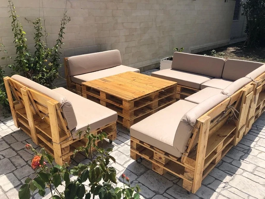 Садовий диван з піддонів, зроблений власноруч, на зеленій галявині