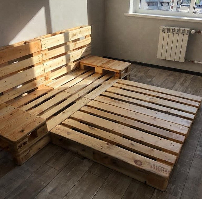 Недорогий диван з палет з подушками різного розміру та кольору