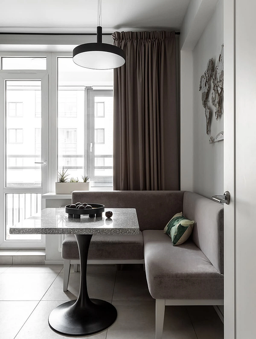 Невеликий кухонний диван з яскравою оббивкою та місцем для зберігання речей.