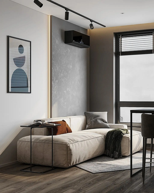 Світла вітальня з великим диваном білого кольору, що підкреслює мінімалістичний дизайн і простір