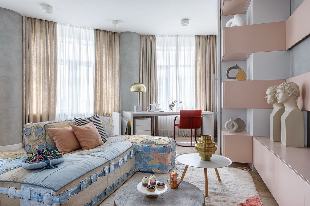 Світлий диван в інтер'єрі вітальні з килимом та журнальним столиком