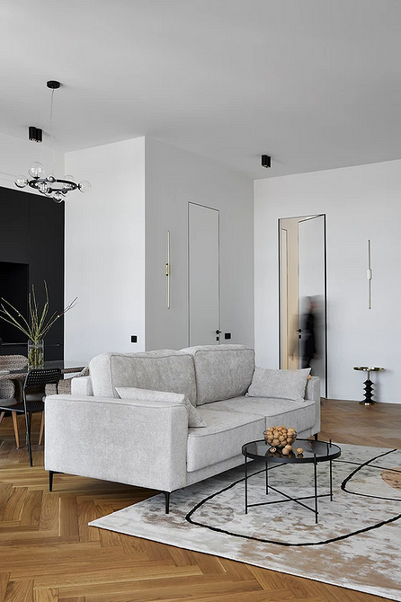 Інтер'єр з темним диваном та великою кількістю декоративних подушок різних кольорів