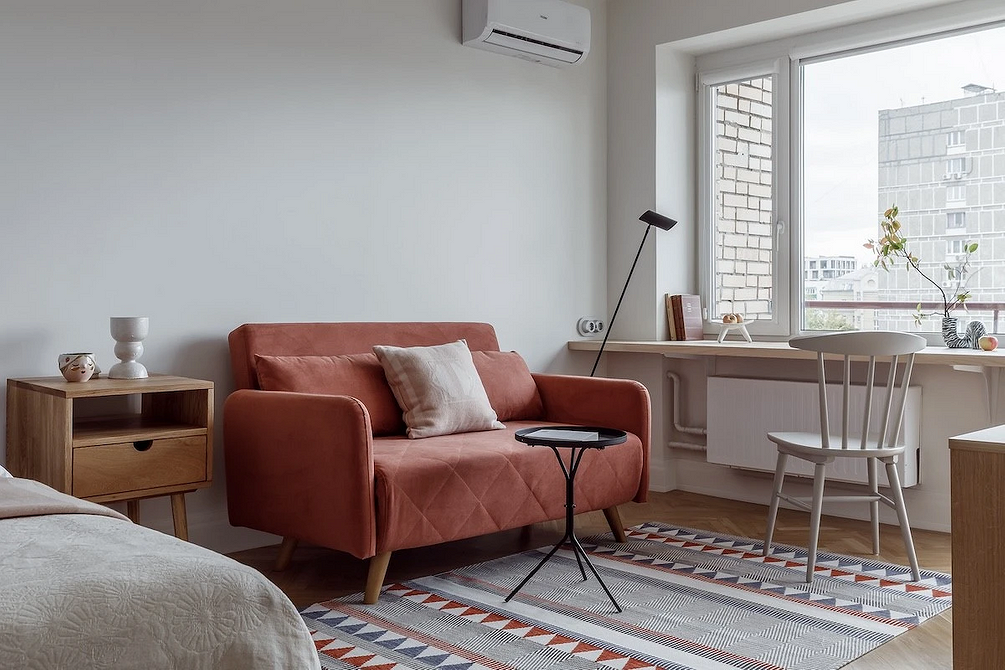 Світла вітальня з контрастним темним диваном та великим вікном