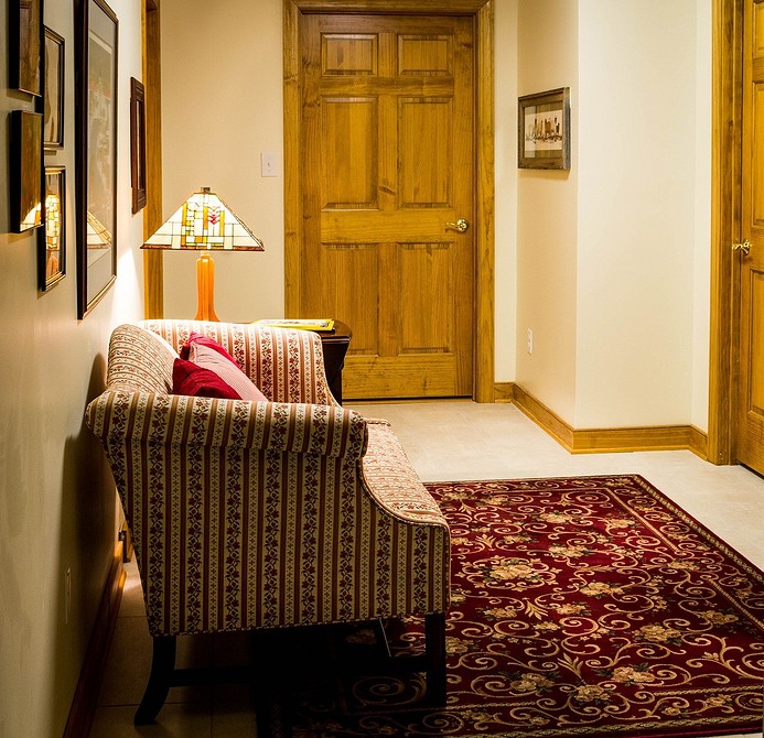 Темний диван з глибокою посадкою в інтер'єрі з великою кількістю рослин.