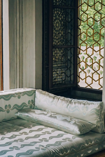 Темний диван з оббивкою під оксамит, в інтер'єрі з яскравими акцентами.