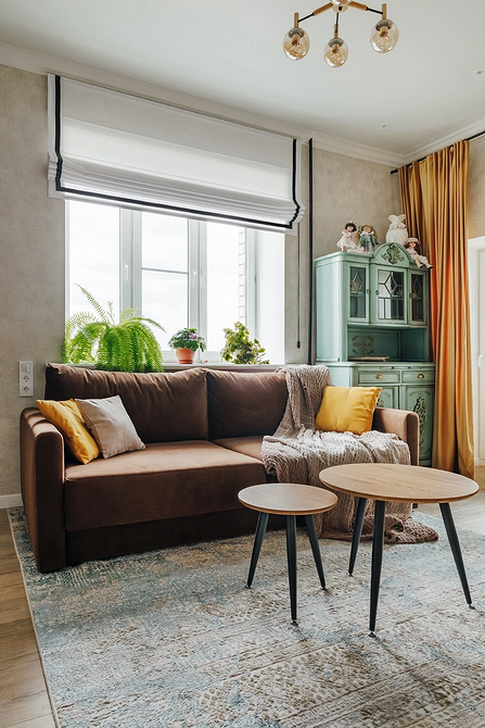 Темний кутовий диван у просторій вітальні: ідеальний вибір для великої родини