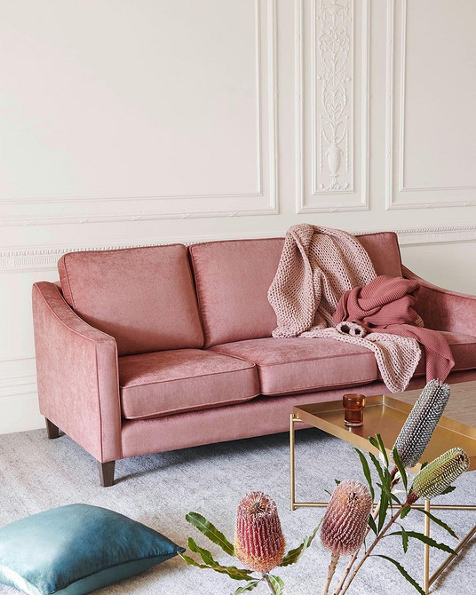 Дизайн вітальні з яскравим диваном, що контрастує з темним паркетом на підлозі