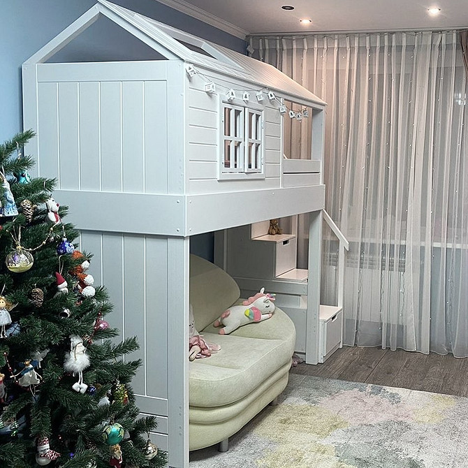 Інтер'єр дитячої кімнати з двоярусним ліжком, диваном та робочим столом.