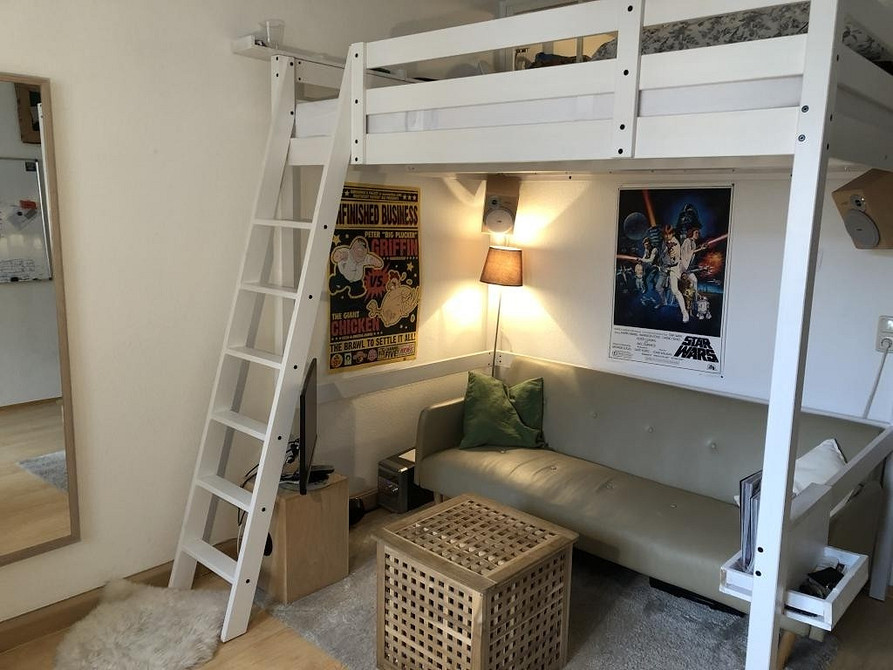 Інтер'єр кімнати підлітка з ліжком-горищем та зручним диваном для відпочинку.