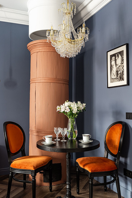 Вінтажні меблі 70-х: дерев'яний стіл та стільці в сучасному інтер'єрі вітальні.