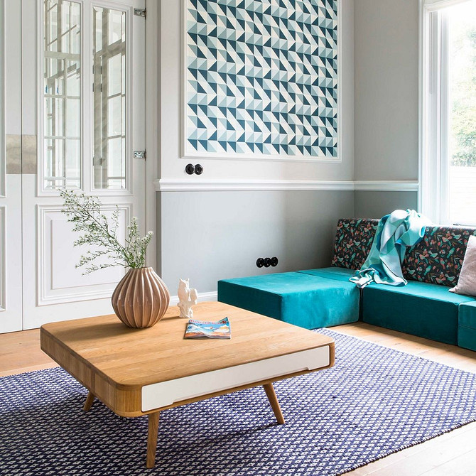 Затишна вітальня з бірюзовим велюровим диваном та декоративними подушками в тон.
