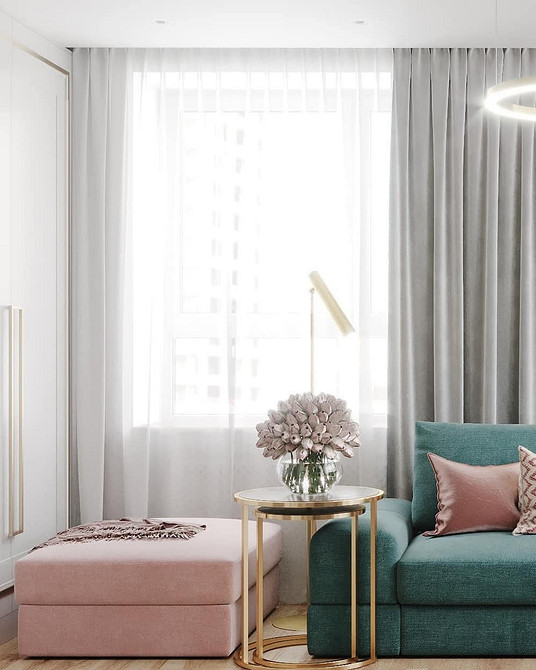 Інтер'єр вітальні з бірюзовим диваном та декоративними подушками різних кольорів.