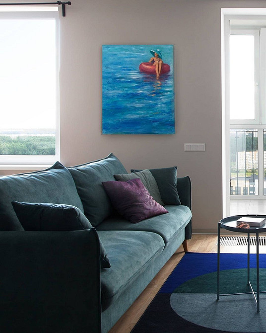 Бірюзовий кутовий диван у просторій вітальні з великими вікнами, м'які меблі