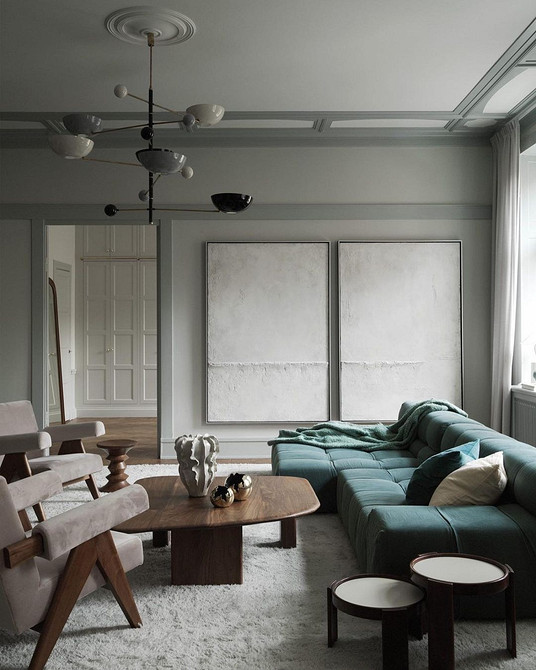 Інтер'єр спальні з бірюзовим диваном, прикрашеним декоративними подушками та пледом