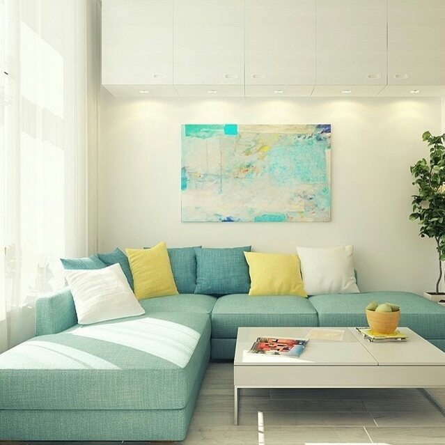 Бірюзовий диван в інтер'єрі з килимом в тон та декоративними рослинами