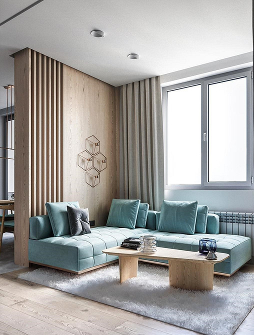 Бірюзовий диван в інтер'єрі вітальні з дерев'яними елементами та килимом