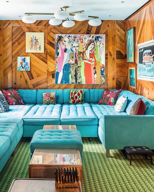 Елегантний бірюзовий диван в інтер'єрі з темними дерев'яними меблями та золотими деталями