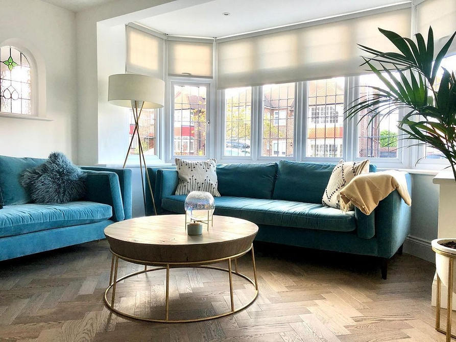 Інтер'єр з бірюзовим диваном, каміном та книжковими полицями.