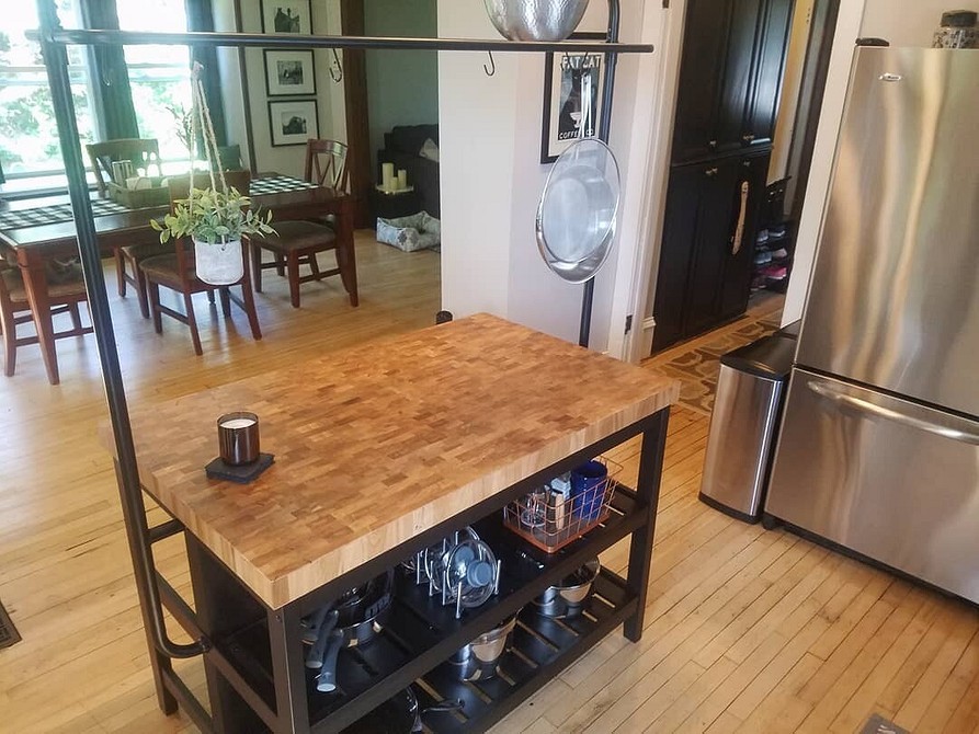 Сучасний мобільний кухонний острів IKEA з дерев'яною стільницею та білими шафами для кухні.