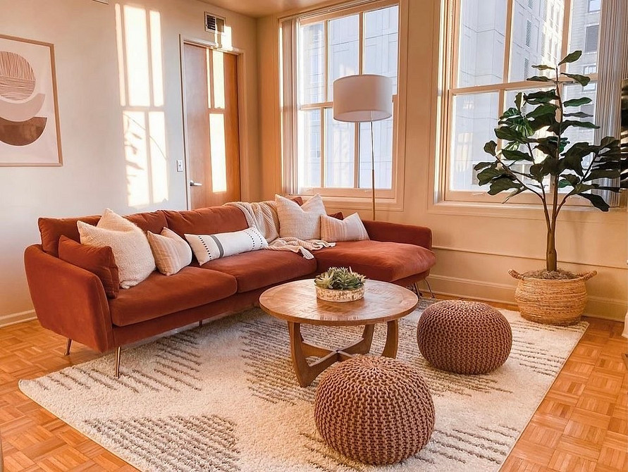 Зелений диван в інтер'єрі вітальні, гармонійно поєднаний з природними відтінками.