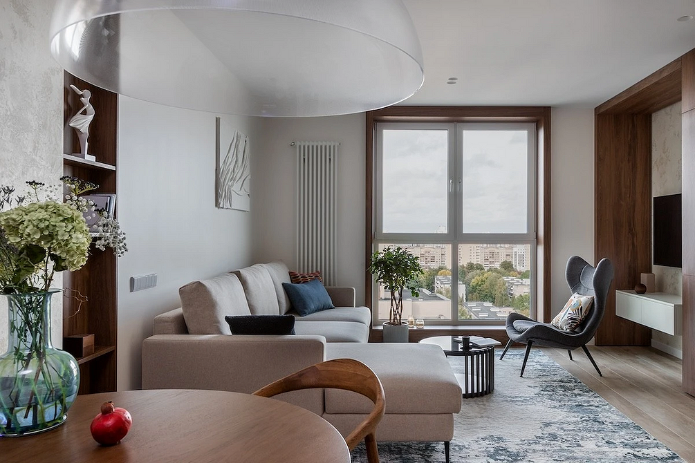 Стильний дизайн кухні-вітальні з великим кухонним островом та обідньою зоною біля вікна.